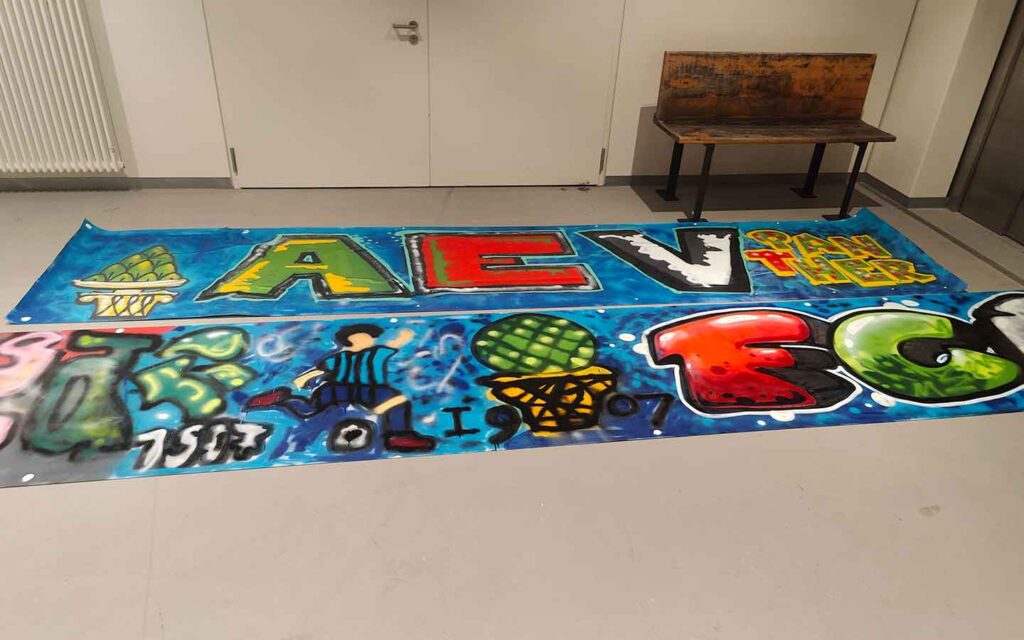 Graffiti-Sprühworkshop in der Handwerkskammer Schwaben mit den Nachwuchsspielern der Augsburger Panther Eishockey-Club und dem FCA Fußballverein. Die besprühten Tapeten liegen im Trockenraum zum Trocknen aus und wurden anschließend von den Vereinen abgeholt.