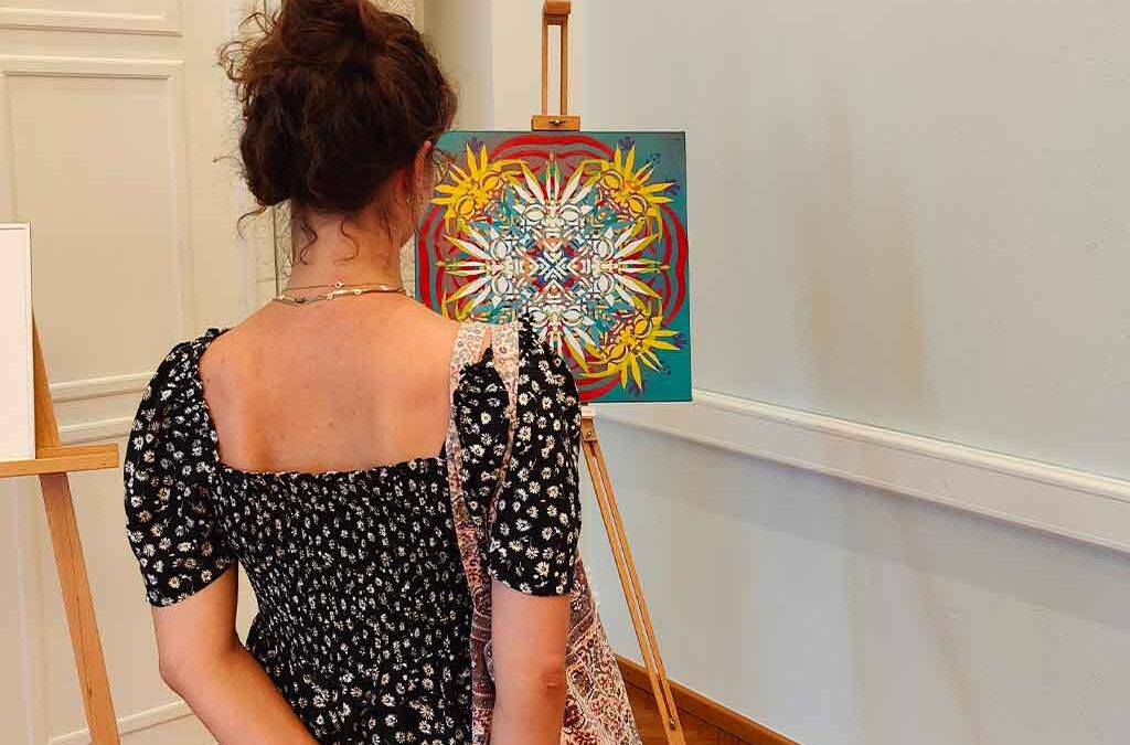 Eine Frau blickt auf ein preisgekröntes Kunstwerk von ErwaOne im Rahmen der Seerosenkreis Ausstellung im Künstlerhaus von München