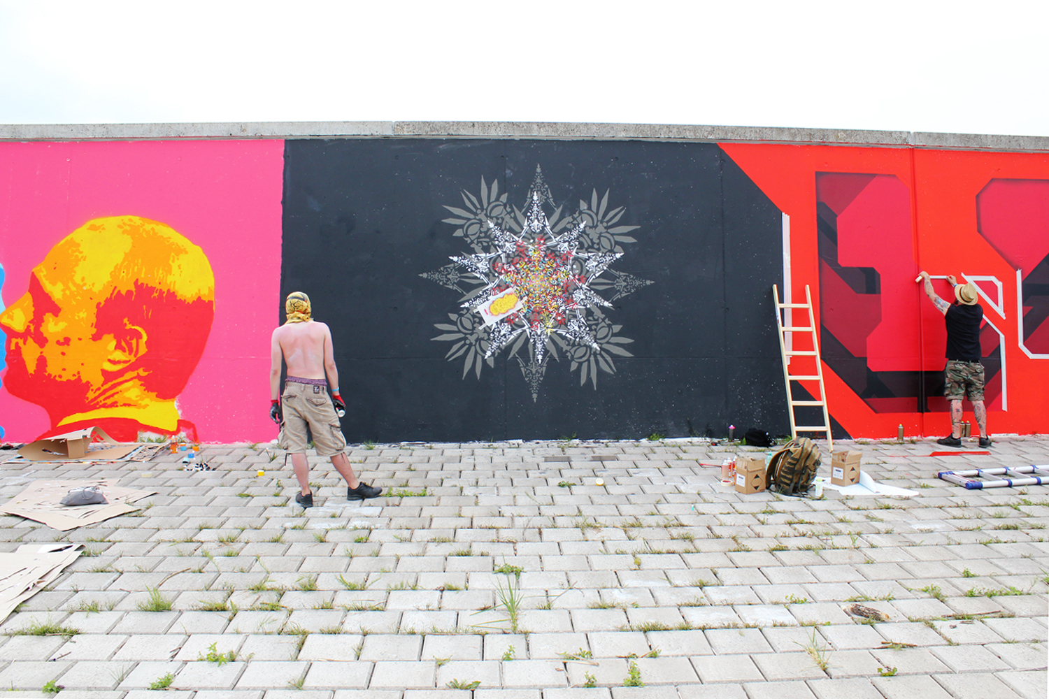 ErwaOne vor seinem Wandbild Streetart Urban Art Farbflut Festival 2018 Deichmauer
