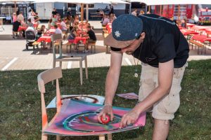 Unternehmensevent Streetart ErwaOne in Landsberg. Der Künstler sprüht eine Schablone des Logos des Kundens auf Karton
