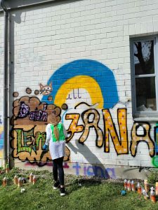 Ukrainisches Mädchen vor bunter Graffiti-Wand, Graffiti-Workshop in Deutschland, Bayern