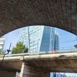 Blick unter einer Brücke mit einem Hochaus im Hintergrund. Urbane Kultur und Urbanität
