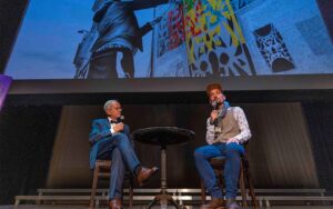 Laudator Axel Flörke und Kulturförderpreisträger Erwa.One im Stadttheater Landsberg, 2022. Urban Art des Künstlers als Fotoprojektion im Hintergrund