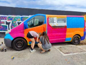 zwei jugendliche besprühen einen Opel Vivaro Bus im Rahmen eines Graffiti und Streetart Workshops in Ettringen / Allgäu