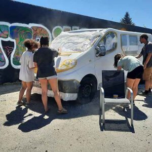 Jugendliche grundieren einen Kleinbus Opel Vivaro mit einem weißen Primer im Rahmen eines Sprühworkshops mit Erwa.One
