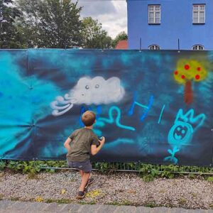Graffiti Workshop Herrsching 2023 Stellwerk / Haus der Jugend, Einführungsworkshop ins Sprühen, Kleiner Junge sprüht eine graue Wolke, Ort legale Wand Gemeinde Herrsching am Ammersee, Jugendarbeit