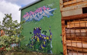 Bavarian Safari Graffiti Jam Landsberg 2023 Graffiti auf Rückseite Resek Joysis, Verein die Bunten e.V. aus Augsburg, grüner Hintergrund, Gewerbehalle