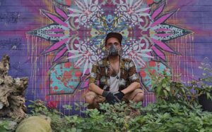 Neue Ornamente Streetart - Secret city Fassadenfestival - Paderborn - 2023 im Bild der Künstler Erwa.One mit Sprühmaske vor seinem fertigen Mandala Kunstwerk, dem "paderstern"