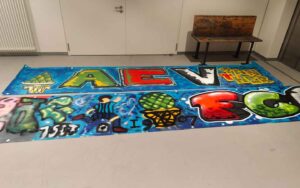 Graffiti-Sprühworkshop in der Handwerkskammer Schwaben mit den Nachwuchsspielern der Augsburger Panther Eishockey-Club und dem FCA Fußballverein. Die besprühten Tapeten liegen im Trockenraum zum Trocknen aus und wurden anschließend von den Vereinen abgeholt.