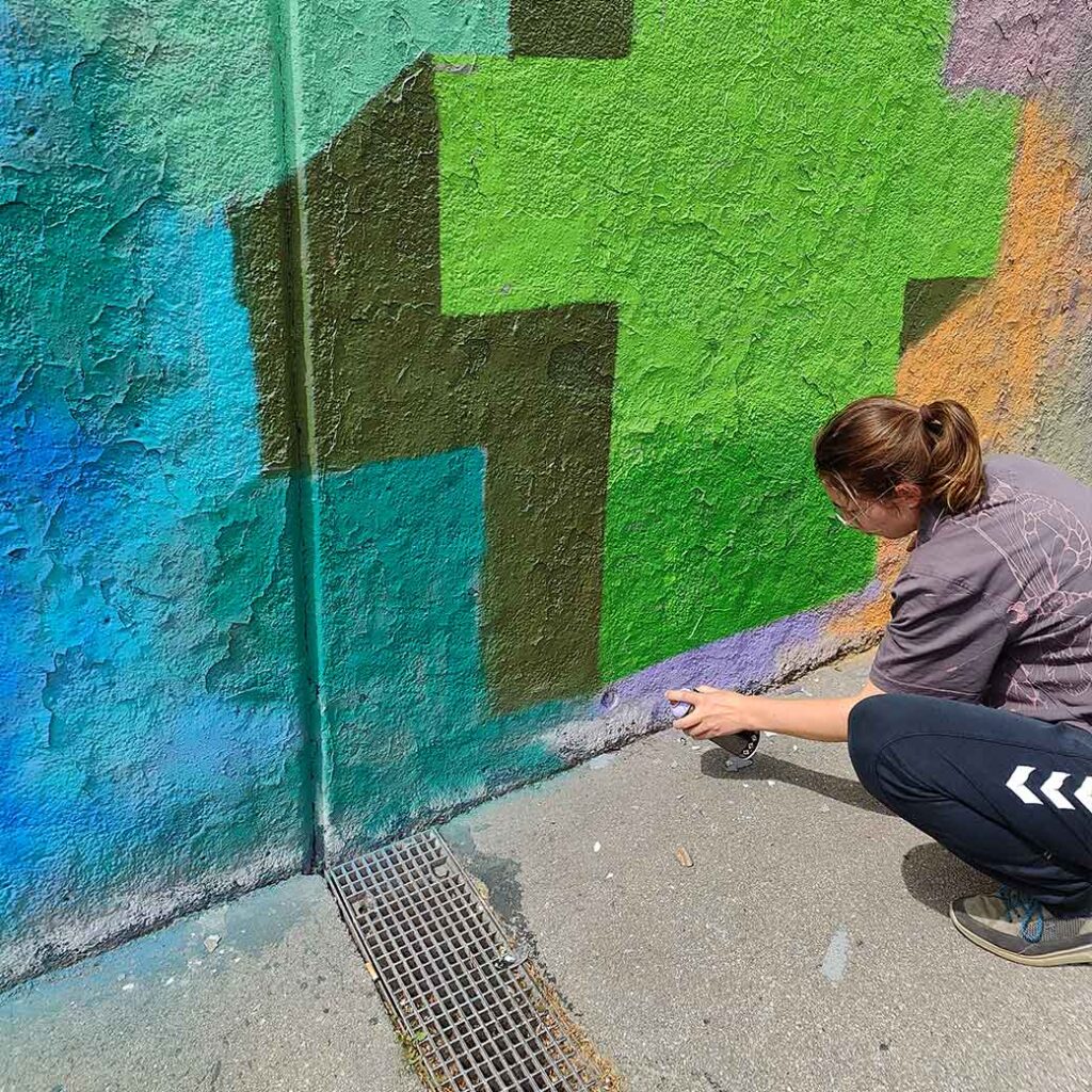 Einführungssprühkurs an den legalen Graffiti Flächen der Stadt Landsberg am Lech in Oberbayern. Streetart Stipendiatin Emma Schindelmann