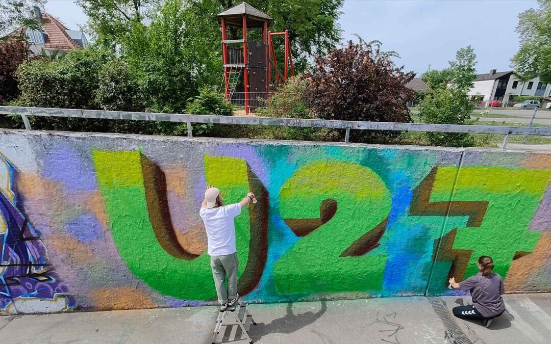 Streetart Stipendiat Bjarne Jaschhof am Sprühen. Einführungssprühkurs an den legalen Graffiti Flächen der Stadt Landsberg am Lech in Oberbayern.