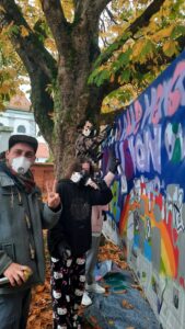 Demokratiebildung Bannergestaltung mit dem Jugendparlament von Ettringen Streetart Kunst Projekt mit Erwa.One und dem Kreisjugendring Unterallgäu, Foto mit dem Künstler und zwei Teilnehmerinnen