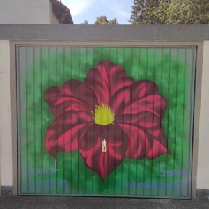 U27 Streetart Stipendium Landsberg 2024: Kunstwerk einer roten Blume auf dem Tor einer Garage in Landsberg durch Stipendiatin Emma