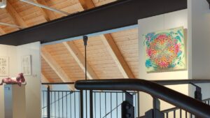 KULT Kunst Krumbach 2024 Kunstausstellung im mittelschwäbischen Heimatmuseum in Krumbach Schwaben, Blick auf die Ausstellung mit einem Kunstwerk von ErwaOne,modernes Museum mit Holzdecke und Stahlträgern, angenhemes Ambiente