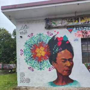 Streetart-Begegnung zwischen den Kulturen mit Lucce aus Toulouse und Erwa.One aus Landsberg. Wandgestaltung am Unser Theater Schwabhausen mit einem Portrait von Frida Kahlo und dem Schablonen-Stil der neuen Ornamente. Sprühdose und Pinsel Kombination, interkulturelle Zusammenarbeit