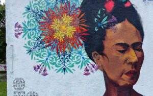 Streetart-Begegnung zwischen den Kulturen mit Lucce aus Toulouse und Erwa.One aus Landsberg. Wandgestaltung am Unser Theater Schwabhausen mit einem Portrait von Frida Kahlo und dem Schablonen-Stil der neuen Ornamente. Sprühdose und Pinsel Kombination, interkulturelle Zusammenarbeit