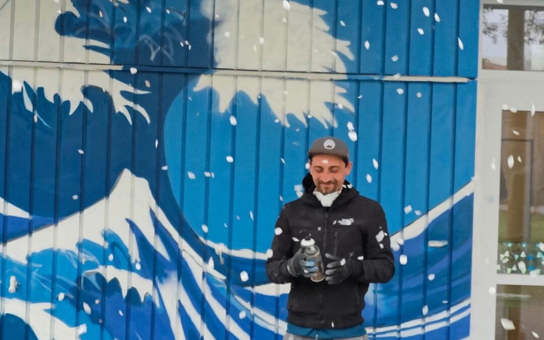 Streetart Künstler und einem blühenden Kirschbaum der seine Blüten verliert.