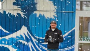 Streetart Künstler und einem blühenden Kirschbaum der seine Blüten verliert.