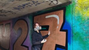 Zwei junge Frauen sprühen gemeinsam ein Graffiti an der legalen Sprühfläche von Landsberg
