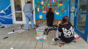 Talentcampus Kaufering Kunstprojekt und Gestaltung des Jugendzentrums Lechside Lounge mit Jugendlichen zum Thema Europa. Drei Mädels gestalten einen Europa-Baum mit Flaggen