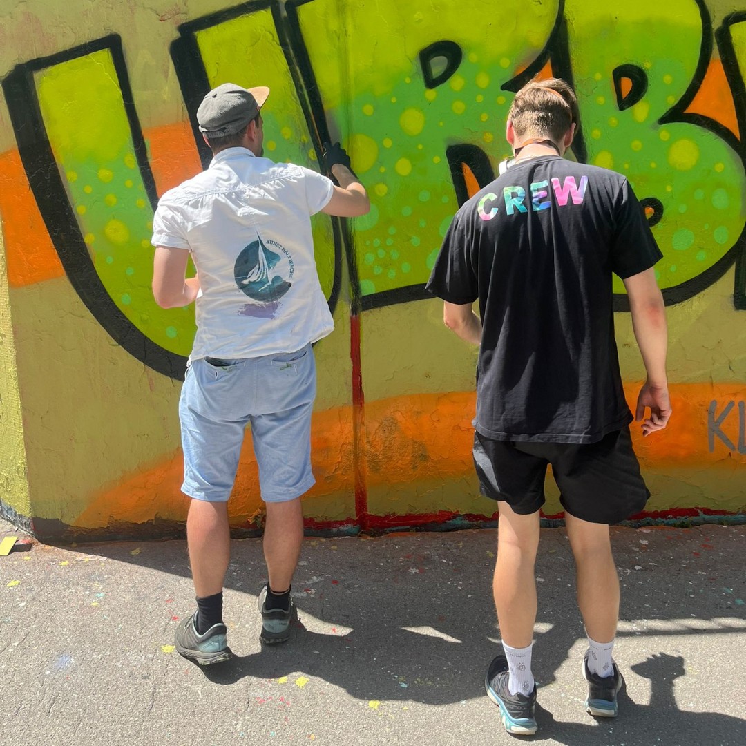 Teambuilding Event Streetart und Graffiti zwei Personen sprühen gemeinsam eine Wandfläche an urbane kultur Augsburg ErwaOne Teamwork und Miteinander