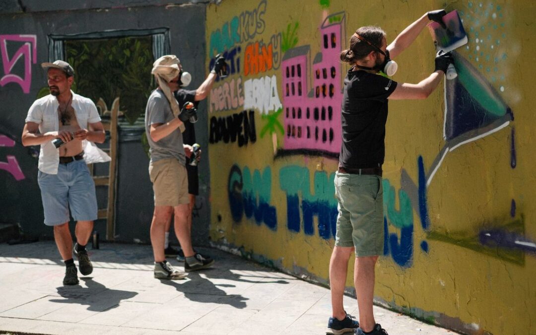 Teambuilding Event Streetart und Graffiti zwei Personen sprühen gemeinsam eine Wandfläche an urbane kultur Augsburg ErwaOne Teamwork und Miteinander