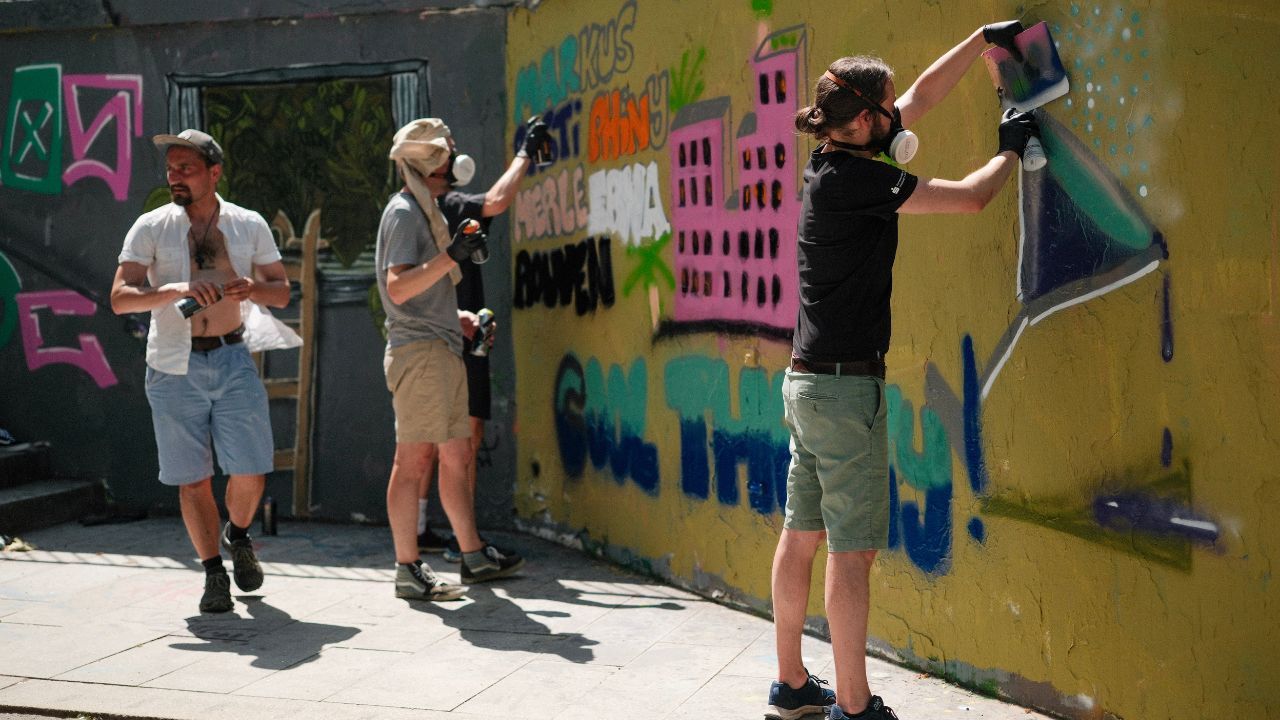 Teambuilding Event Streetart und Graffiti zwei Personen sprühen gemeinsam eine Wandfläche an urbane kultur Augsburg ErwaOne Teamwork und Miteinander