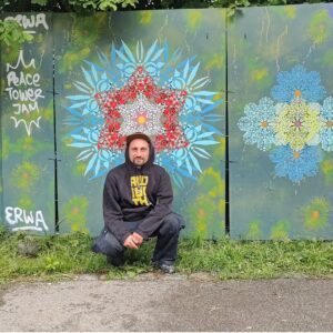 Peace Tower Jam am zukünftigen Studentenwohnheim Lechbrücke in Augsburg. Streetart und Graffiti auf Bauzäunen sorgen für Farbe und Miteinander. urbaner Künstler ErwaOne vor seinem Wandbild