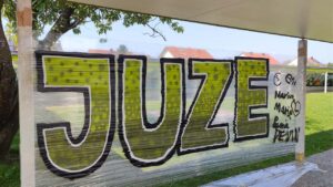 Streetart- und Graffiti Workshop im Rahmen des Ferienprogrammes des Jugendzentrums von Kirchheim an der Grund- und Mittelschule. Das Graffito mit dem Wort JUZE steht auf einer mobilen Folie gesprüht