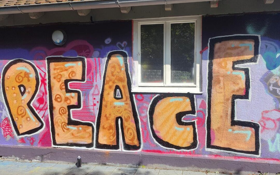 Partizipatives Graffiti aus einem Graffiti- und Streetart Workshop mit Erwa.One in Herrsching am Ammersee. Der Schriftzug Peace / Frieden steht auf einer Wand als Graffito gesprüht.