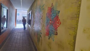 Neue Ornamente by Erwa.one Passagengestaltung der Zederpassage am Hauptplatz von Landsberg am Lech, Streetart und urbane Kunst, professionnelle Auftragsarbeit mit einzigartigen Schablonen-Motiven. Blick auf die Passage. Eine Passantin geht in Richtung Hauptplatz