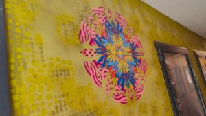 Neue Ornamente by Erwa.one Passagengestaltung der Zederpassage am Hauptplatz von Landsberg am Lech, Streetart und urbane Kunst, professionnelle Auftragsarbeit mit einzigartigen Schablonen-Motiven. Das Ornament ist in rot, rosa und mittig blau und gelb gesprüht