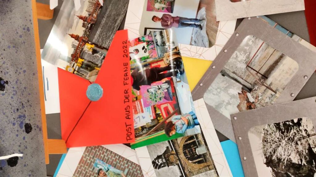 Postkarten und Fotos sowie ein roter Umschlag liegen auf einer Fläche verteilt. Solo Ausstellung des renommierten Künstlers Erwa.one