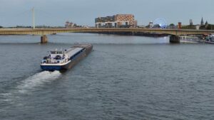 Köln Nordrhein Westfalen Rhein Ein Boot fährt den Fluss entlang. Von weitem ist die Deutzer Brücke zu sehen.