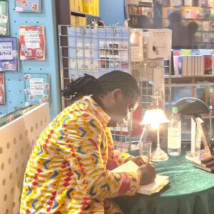 Fann Attiki signiert Bücher nach seiner Lesungzu seinem Buch Cave72 im Buchladen in Augsburg im Rahmen der afrikanischen Woche