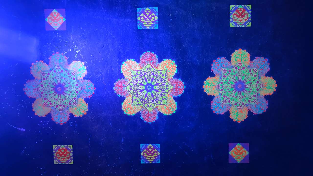 Klangraum Ornament große Wandseite 4 Meter auf 2,2 Meter. Drei Bunte Ornamente werden durch Blaulicht angeleuchtet und leuchten im Dunklen.