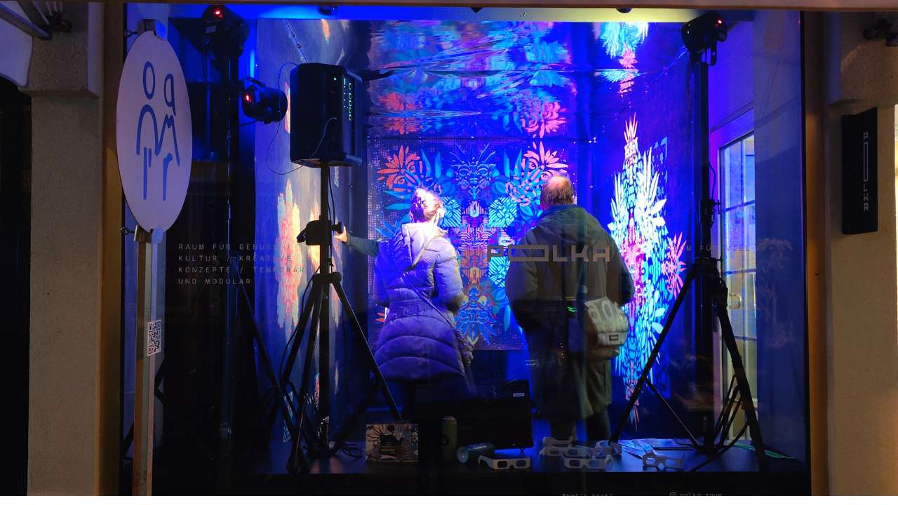Klangraum Installation Pforzheimer Kulturnacht 2025 im POlka-Raum. Foto von der Straße auf das Schaufenster. Im Raum stehen Menschen und bewundern die Installation