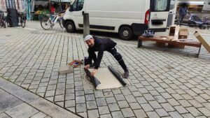 Streetart Künstler druckt in Mindelheim einen abgedruckten Gulli-Deckel während seiner Print-the-City Intervention KulTOURtage Mindelheim Unterallgäu