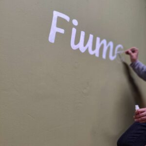 B2B Auftragsgestaltung für einen Gastronomiebetrieb Fiume in Landsberg am Lech. Ausschnitt auf Terrasse Schriftzug Spaghetteria Fiume in Siena-Braun darunter Motiv spaghetti gemalt mit Pinsel