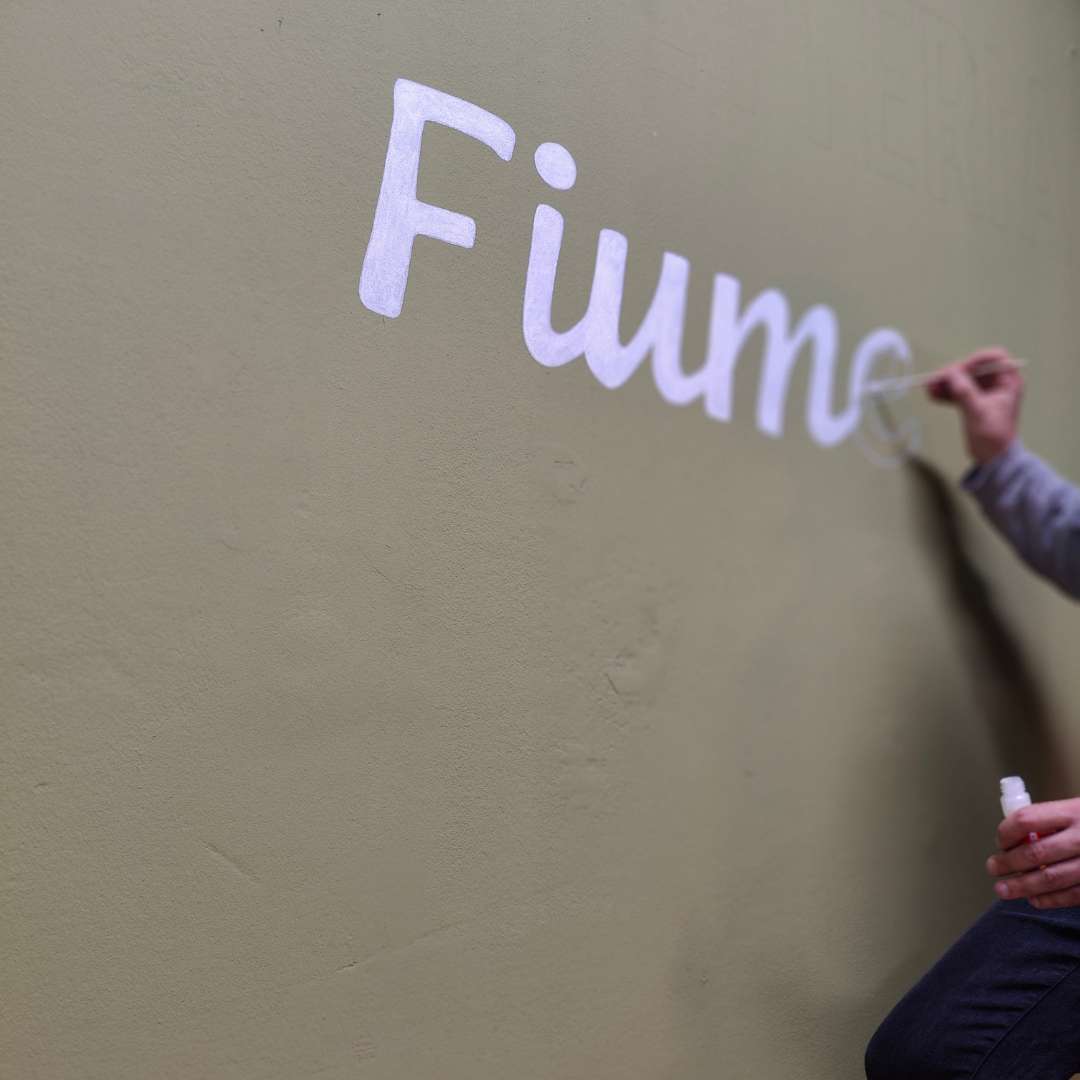 B2B Auftragsgestaltung für einen Gastronomiebetrieb Fiume in Landsberg am Lech. Ausschnitt auf Terrasse Schriftzug Spaghetteria Fiume in Siena-Braun darunter Motiv spaghetti gemalt mit Pinsel