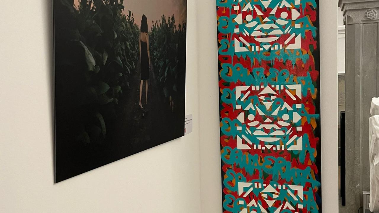 Bildende Kunst im Hofgartensaal der Residenz von Kempten. ein Kunstwerk auf Leinwand hochkant von Erwa.One im Rahmen der Jahresausstellung des BBK Berufsverband bildender Künstler Allgäu Schwaben Süd e.V. auf einer weißen Wand und einem weiteren Kunstwerk daneben